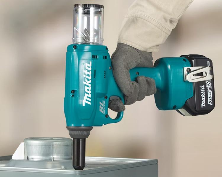 Construction worker using a Makita Rivet Gun to join metal pieces together, highlighting tool efficiency and reliability