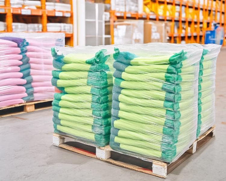 Series of pallets in a warehouse stocked with wiping rags, ready for cleaning and maintenance purposes